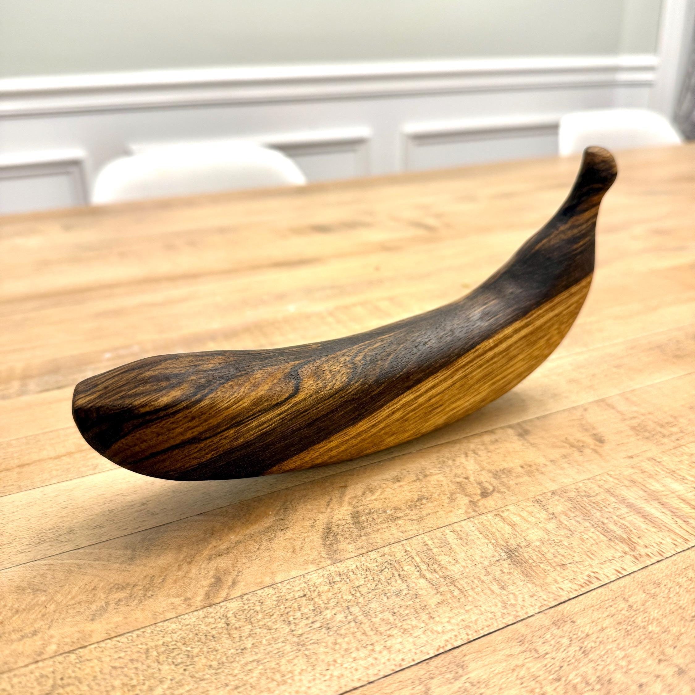 Wooden banana on a wooden table with a blurred background