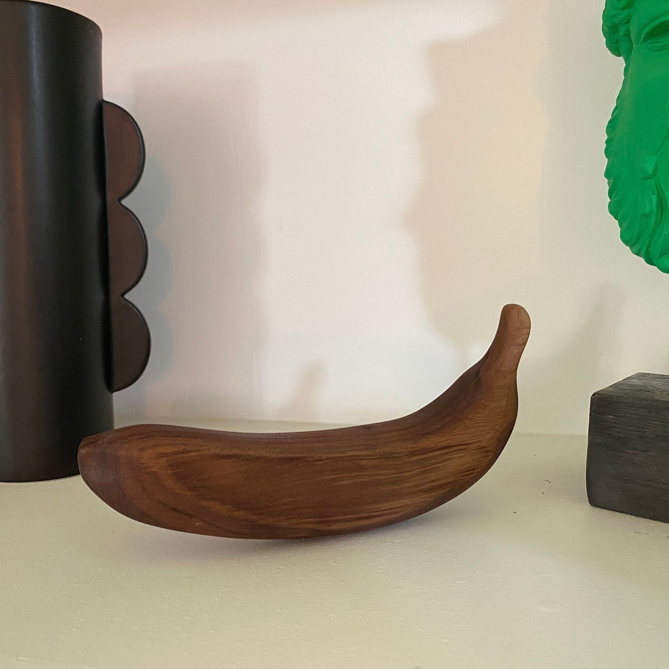 Wooden banana on a shelf with decorative items