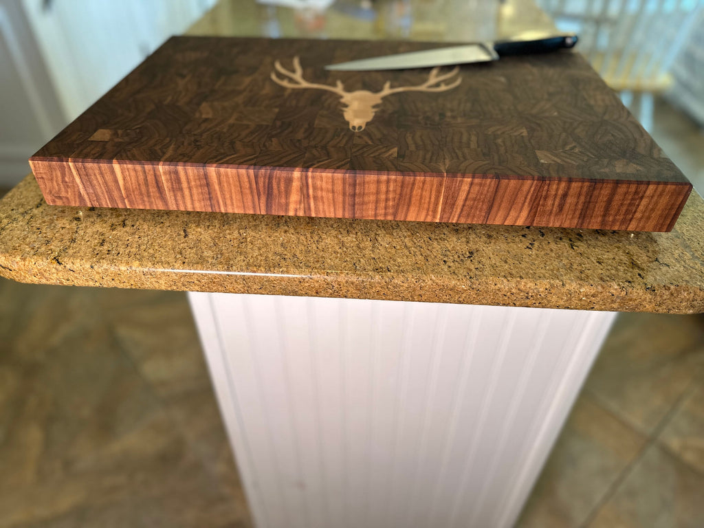 Wooden cutting board with deer design on a kitchen counter