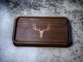 Wooden tray with a deer skull design on a granite surface