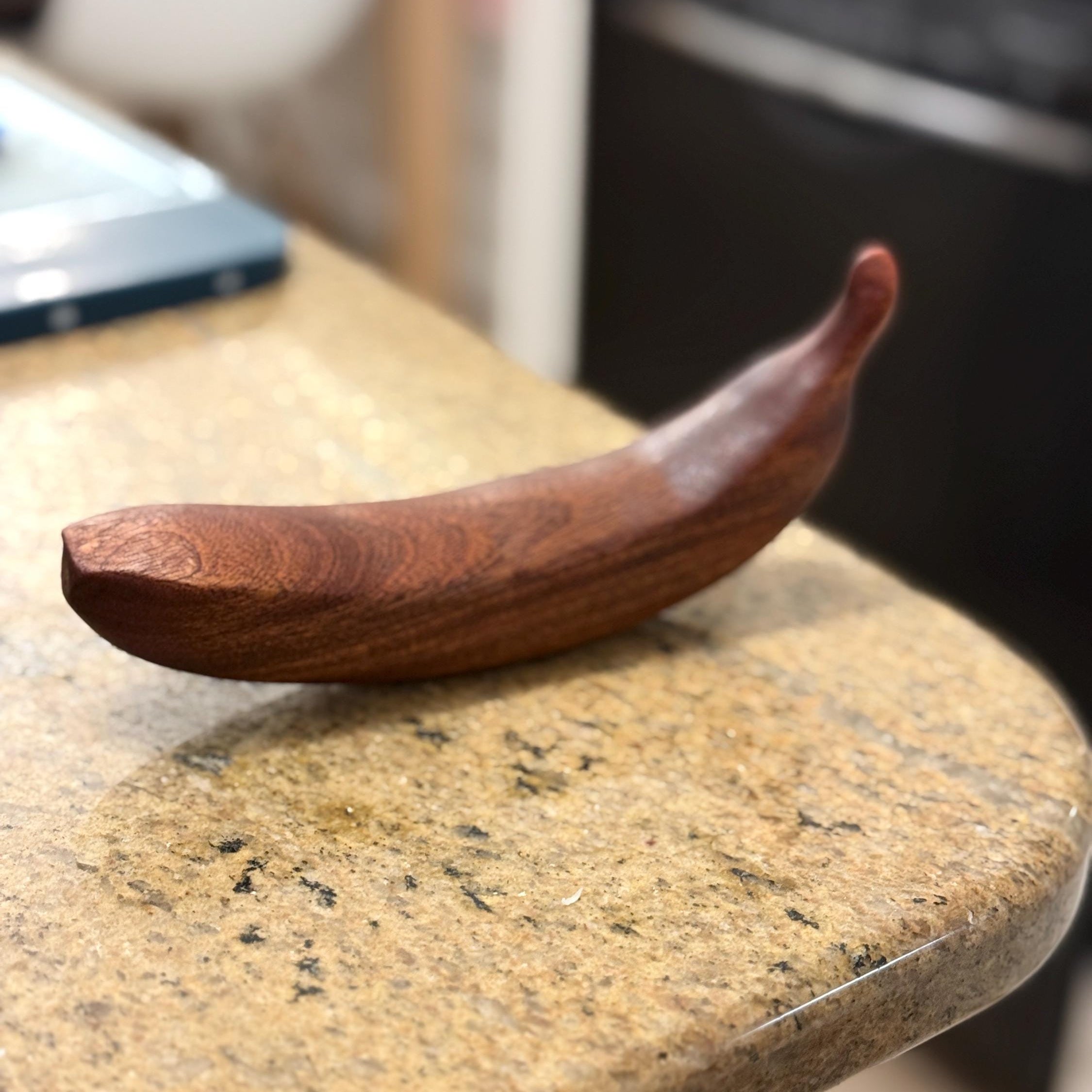 Wooden bananaon a marble surface with a blurred background