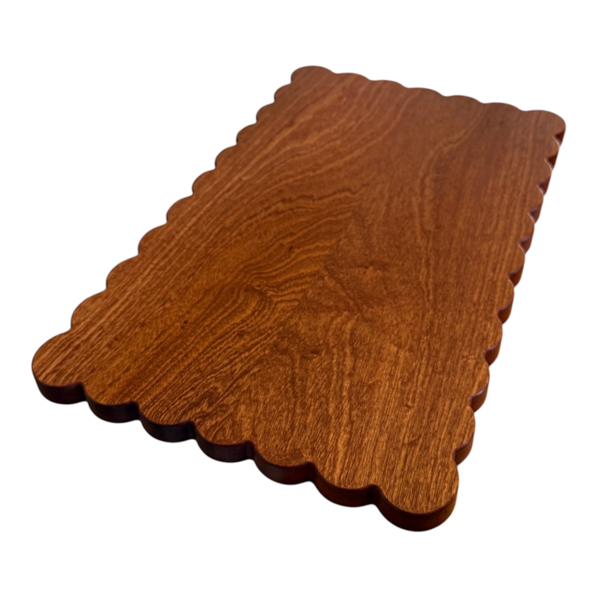 Scalloped mahogany cutting board on white background 