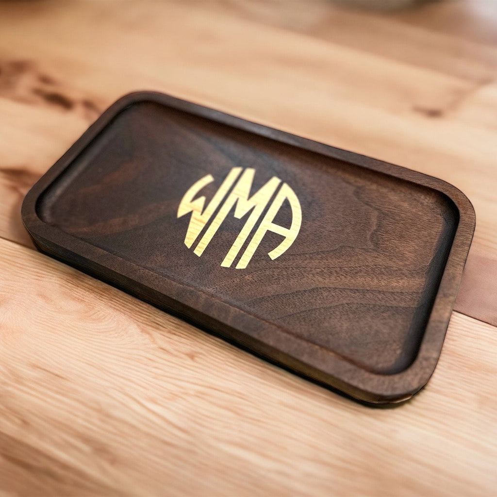 Wooden tray with a monogram on a wooden surface