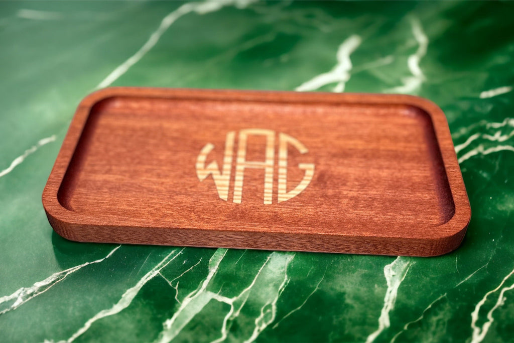 Wooden tray with engraved monogram on a green marble surface