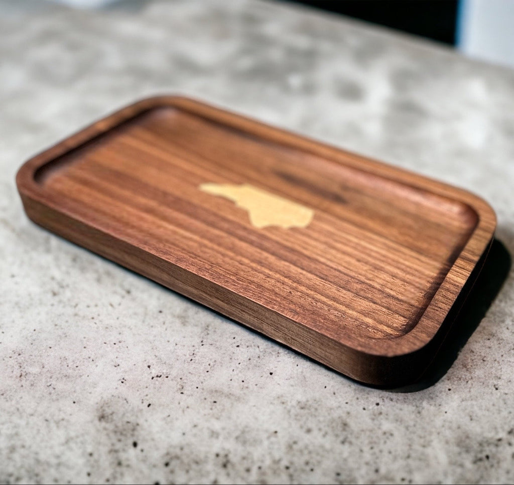 Wooden valet tray  with NC State inlay on a concrete surface