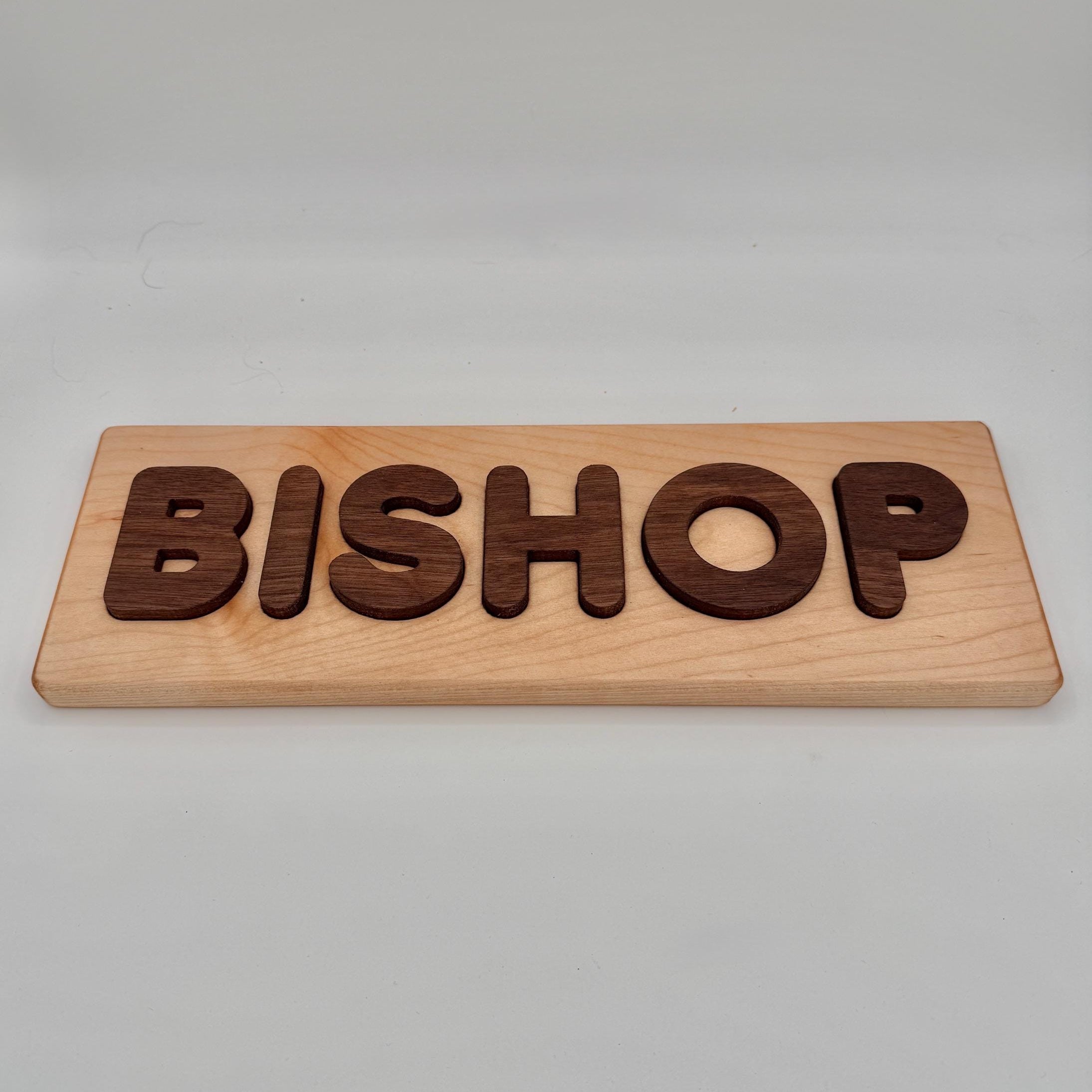 Wooden name puzzle with 'BISHOP' engraved on a plain background