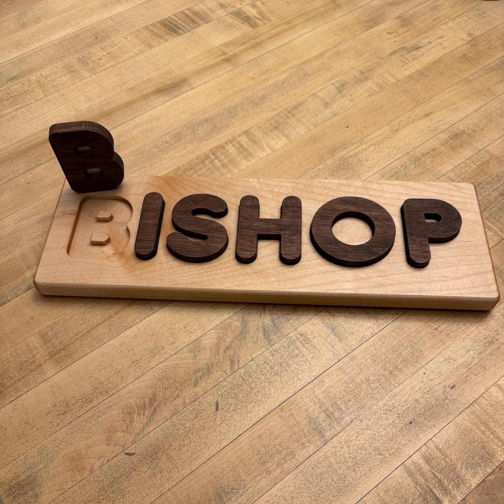 Wooden nameplate with 'BISHOP' on a wooden table