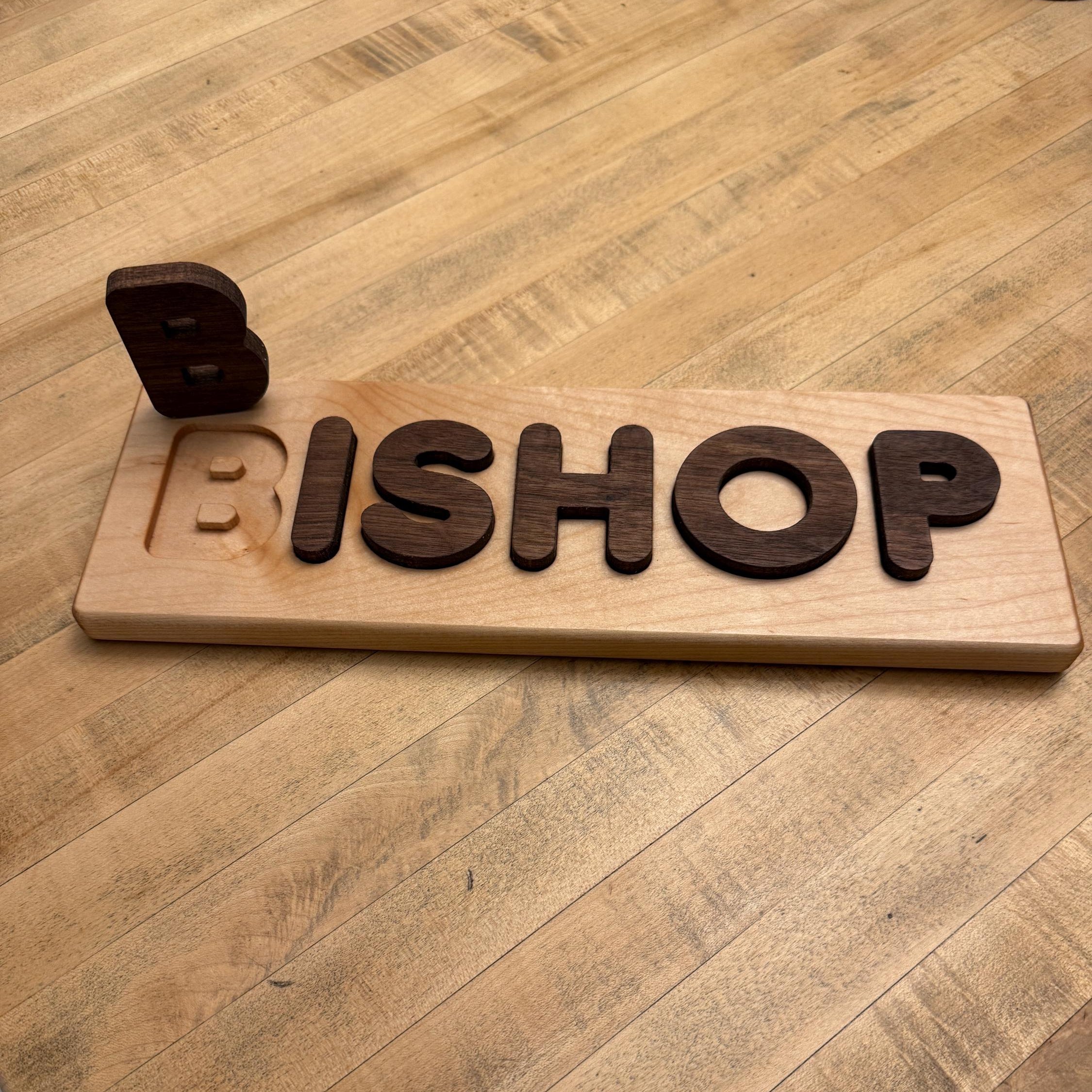 Wooden nameplate with 'BISHOP' on a wooden table