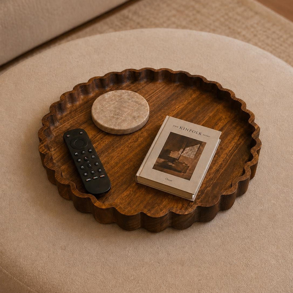 Wooden tray with a book and remote control on a beige ottoman