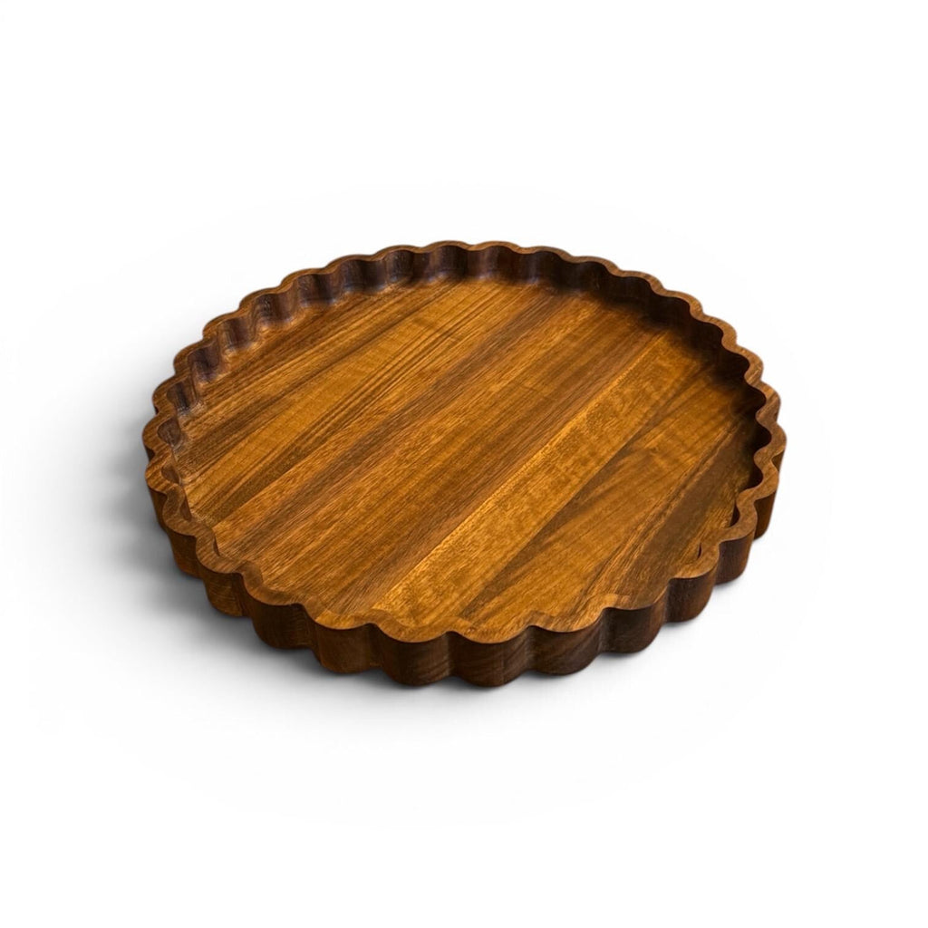 Wooden tray with scalloped edge on a white background