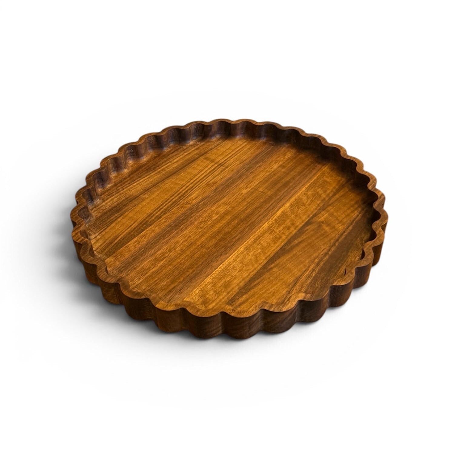 Wooden tray with scalloped edge on a white background