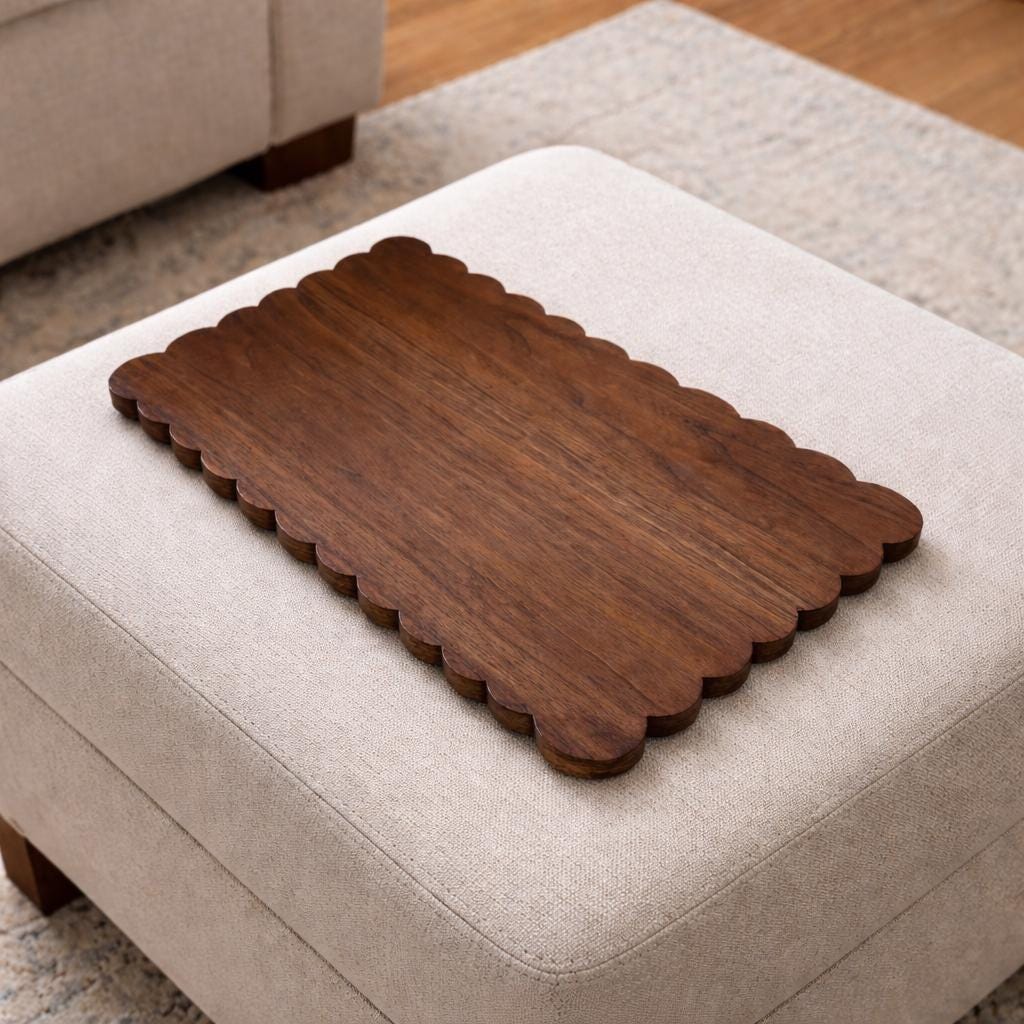 Wooden tray with scalloped edge on a beige ottoman