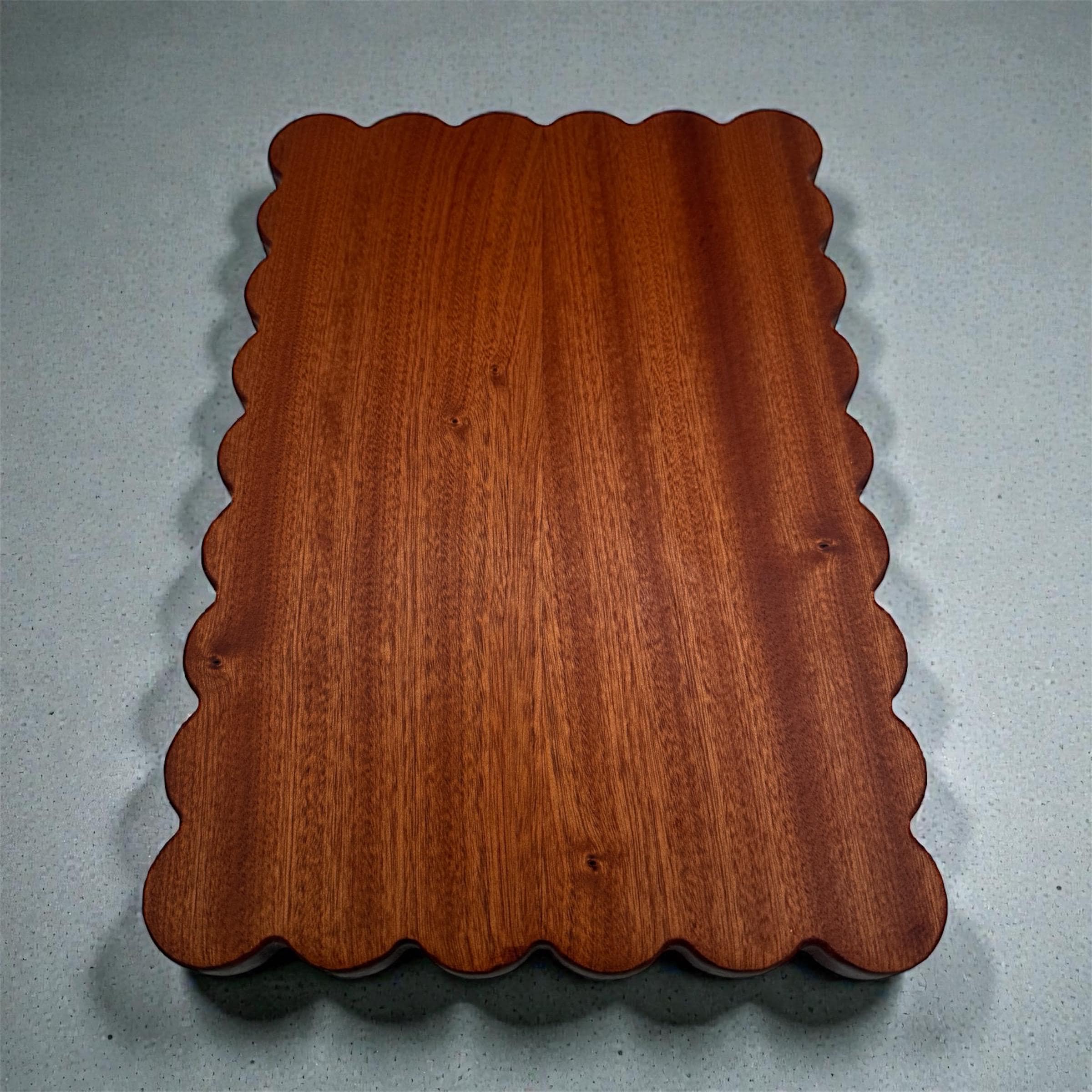 Wooden tray with scalloped edge on a gray background