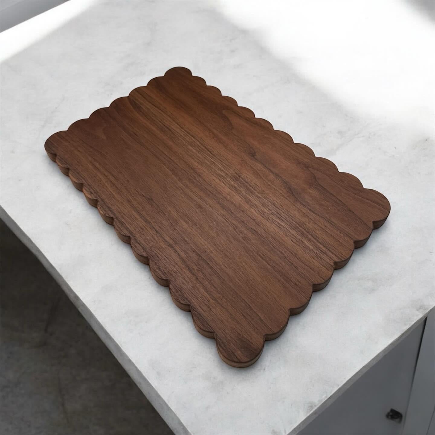 Wooden cutting board with scalloped edge on a marble surface
