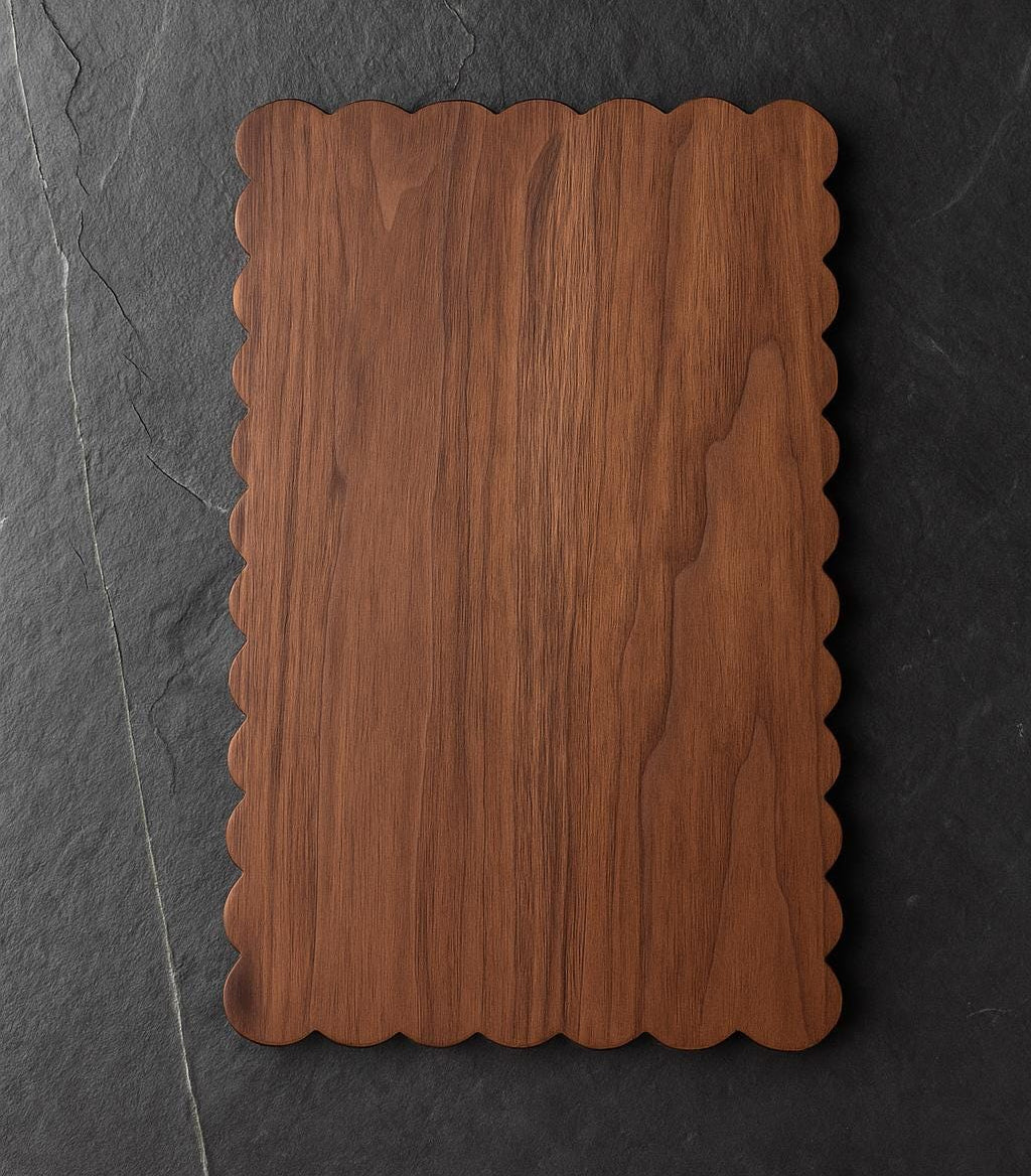 Wooden cutting board with scalloped edge on a dark stone background