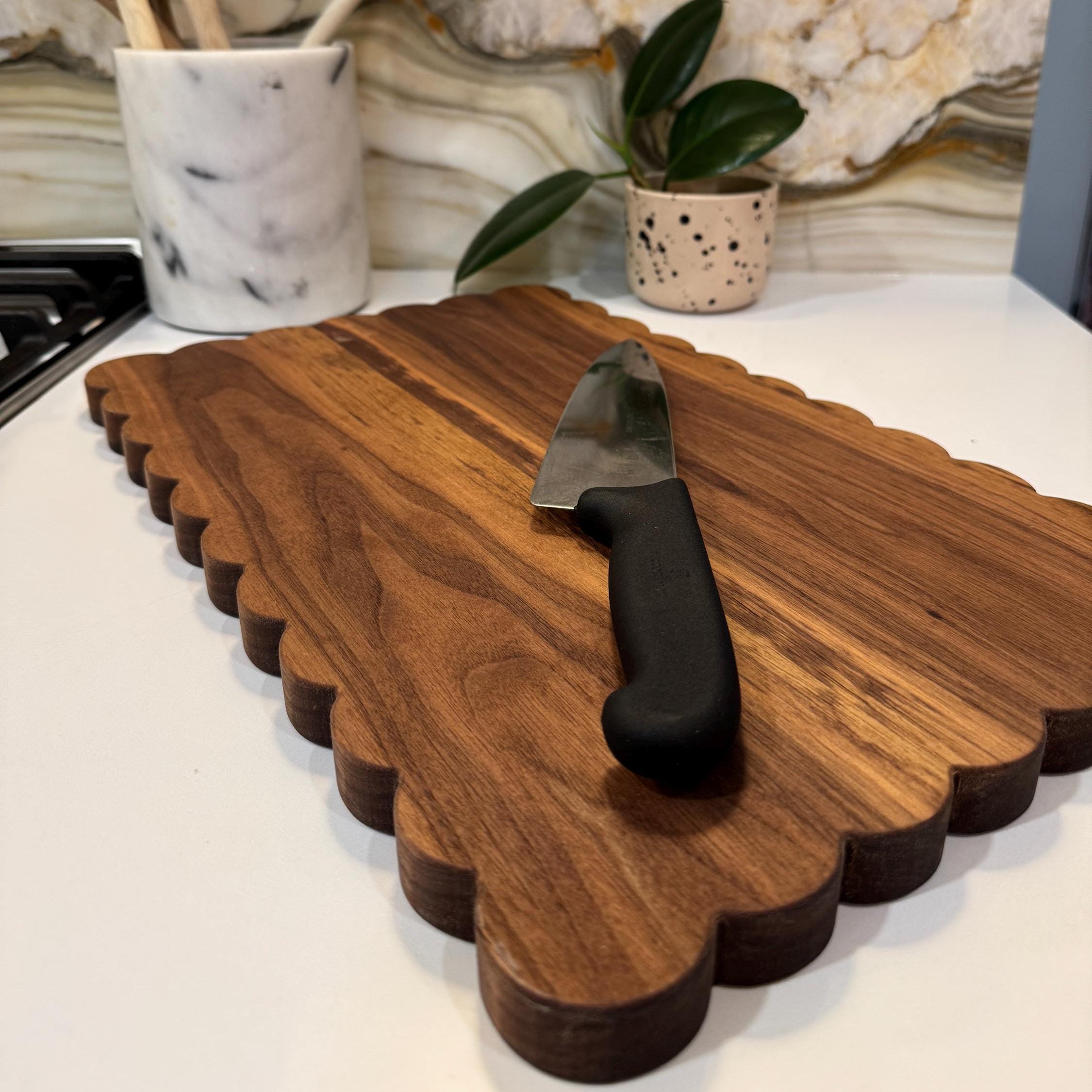 Wooden cutting board with a knife on a kitchen counter