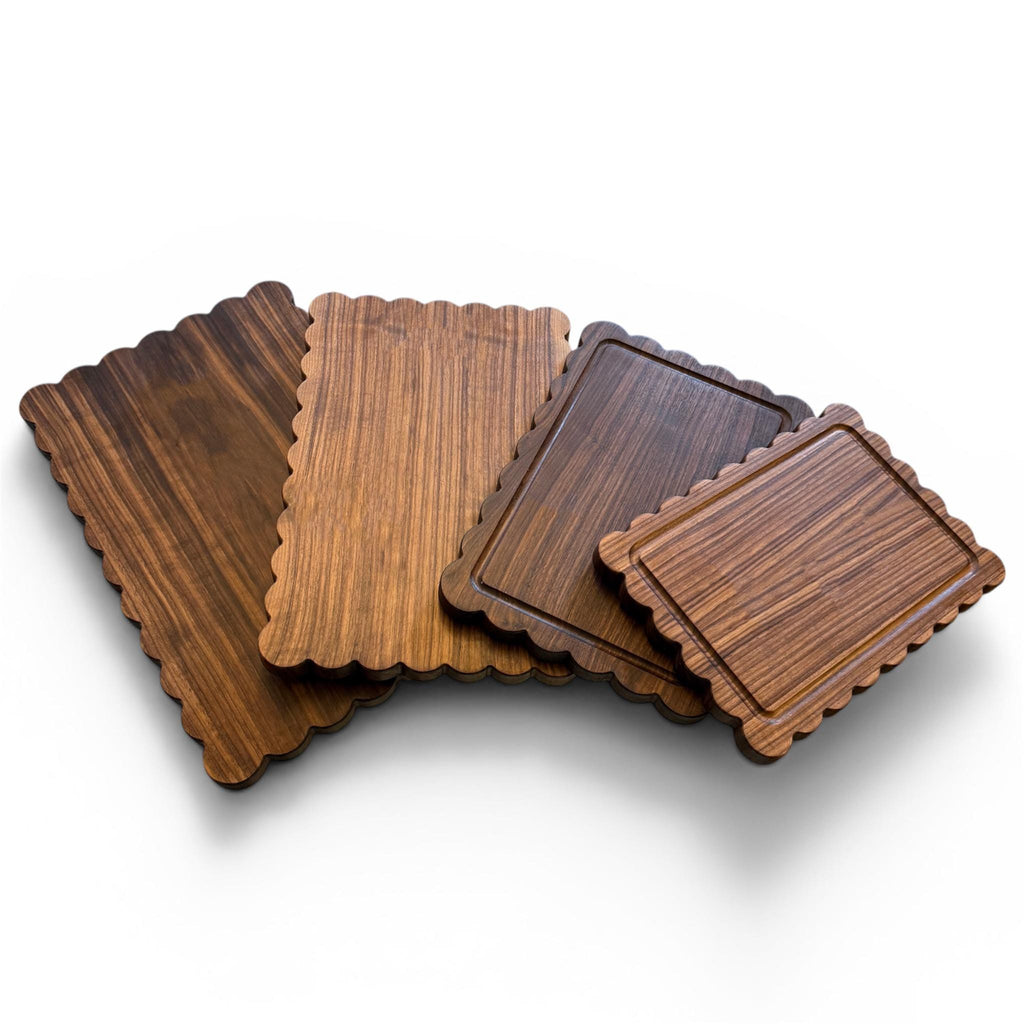 Set of wooden cutting boards with scalloped edges on a white background