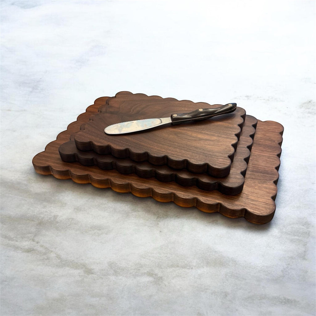 Set of wooden cutting boards with a knife on a marble surface