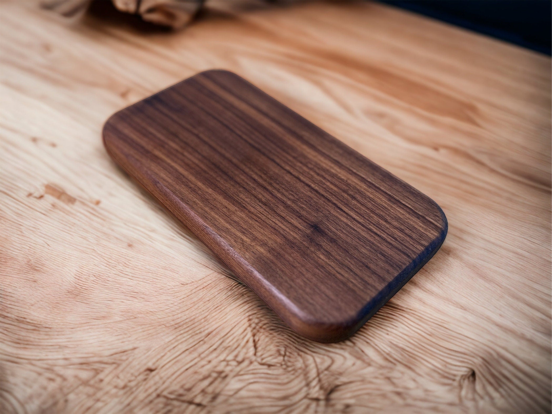 The underside of a wooden valet case. It is made of walnut and it is on a wooden table.