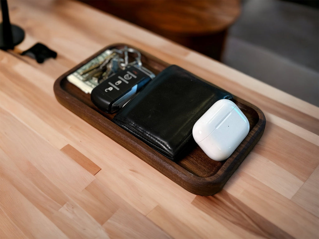 Wooden desk organizer with keys, wallet, and airpods on a wooden surface